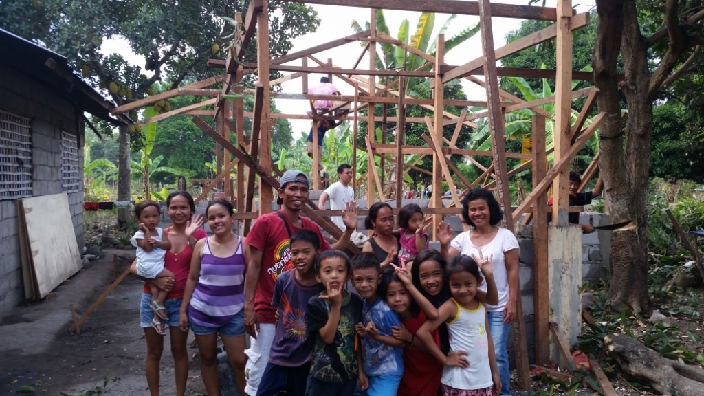 House building familly photo in front of build